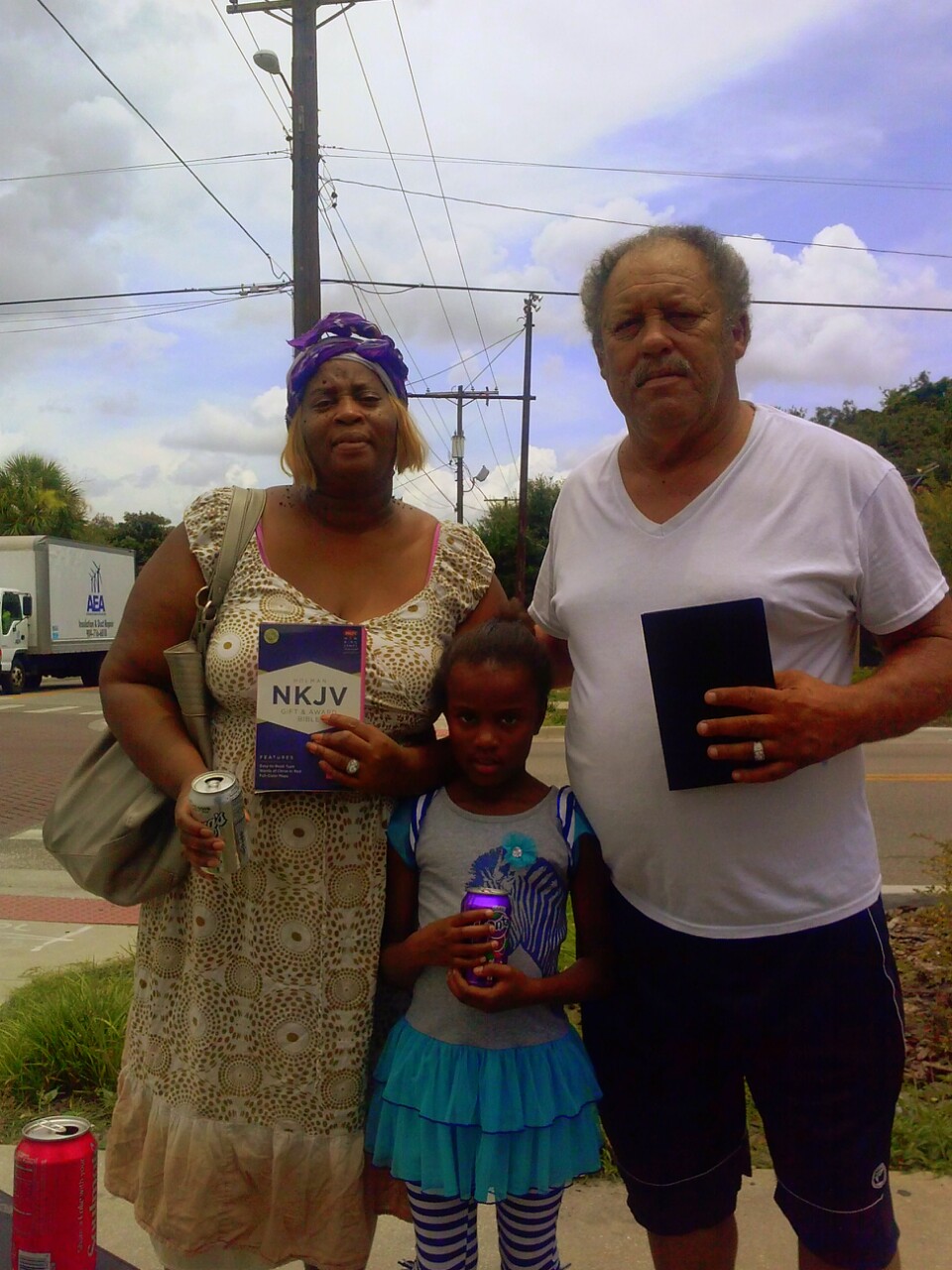 Man, woman & child with their new Bibles